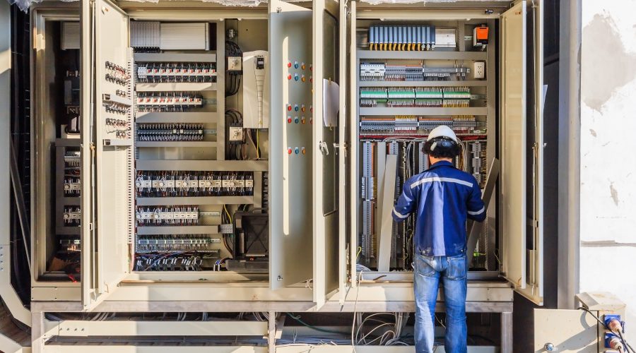 Instrument technician on the job check wiring on PLC cabinet